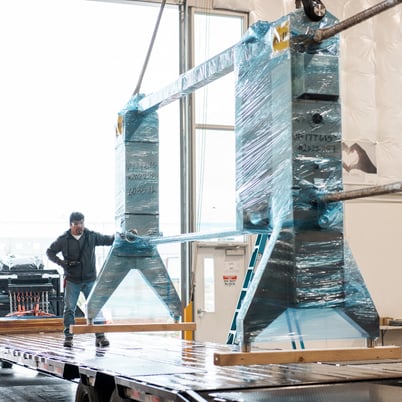 Man stands next to AGC plate heat exchanger wrapped for shipping