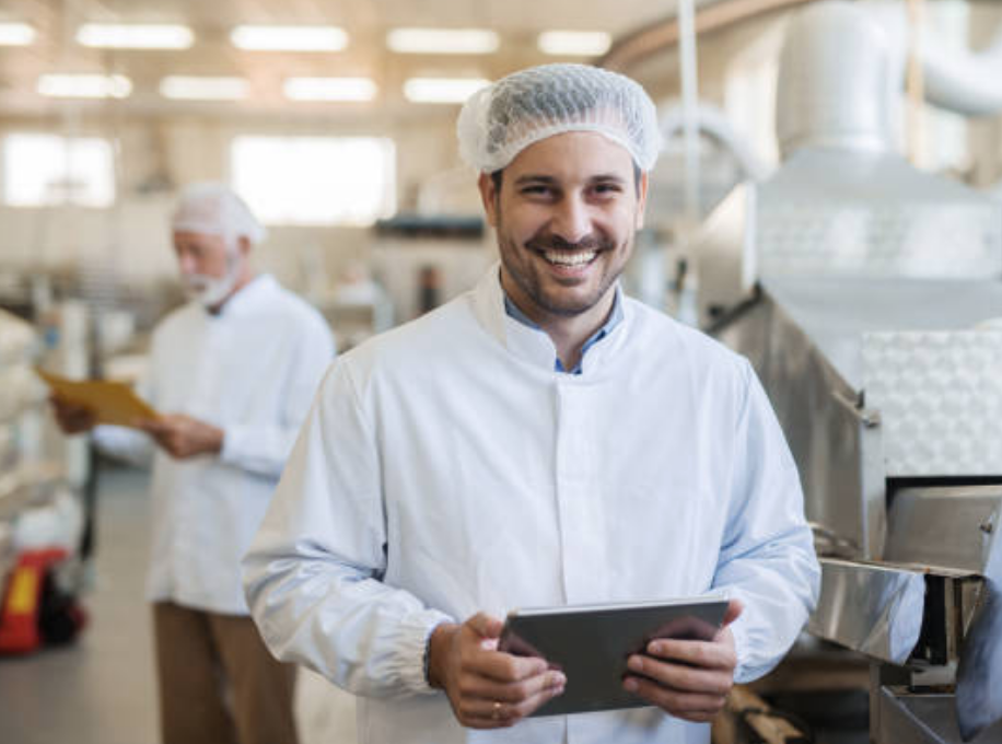 Man smiling while working at a food manufacturing plant