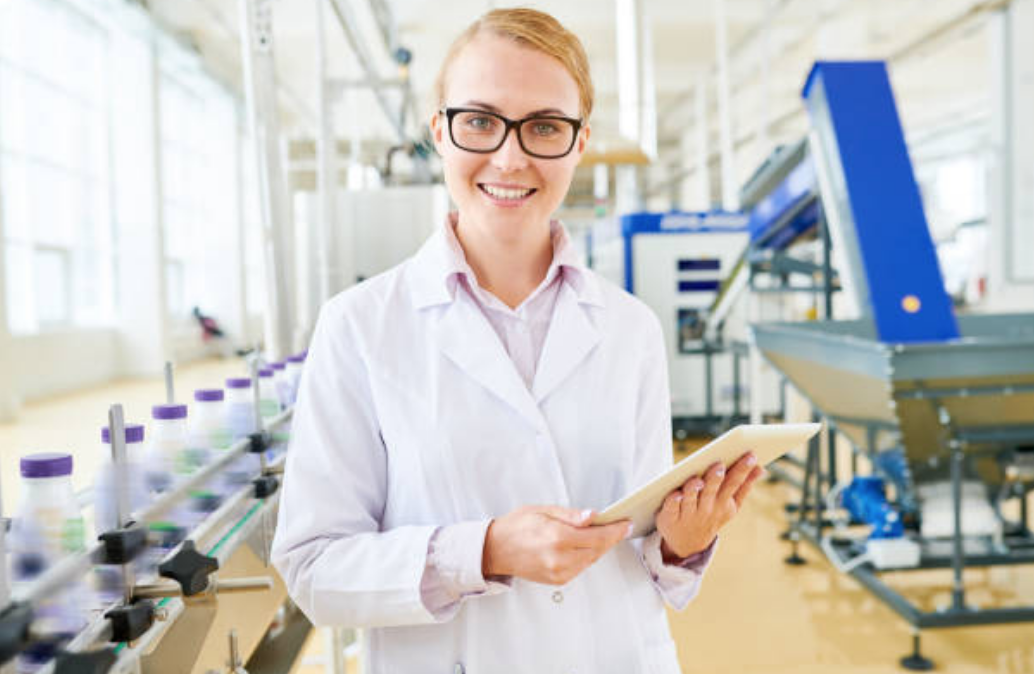 Woman smiling while working in a food manufacturing plan